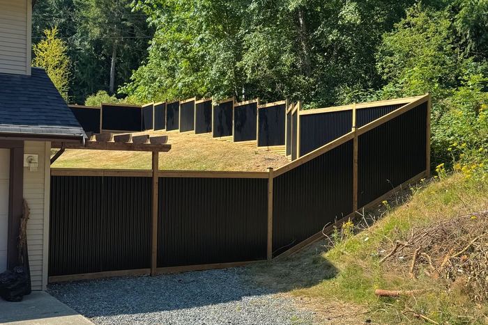 Cedar and metal fence line built by Tonella Contracting